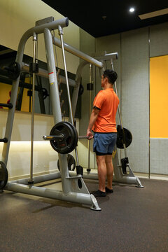 Man doing deadlift with rack machine in private gym