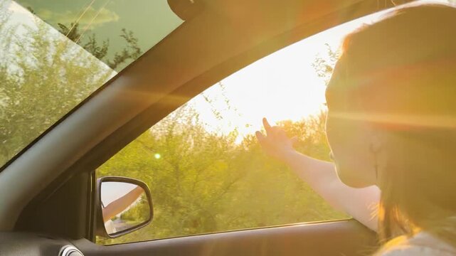 Girl reaching for the sun from a car, peaceful golden hour moment, nature passing by, carefree travel, the joy of open roads, life in motion, relaxing journey, feeling the warmth, road trip vibes