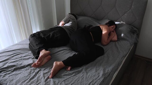 Emotional distance. Couple lying apart in bed, growing apart in relationship, loss of intimacy, emotional disconnection and loneliness despite being together