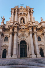 Obraz premium Baroque facade of Syracuse Cathedral against a clear blue sky in Piazza Duomo Ortigia Sicily Italy. Iconic religious landmark and historic architecture in a Mediterranean travel destination
