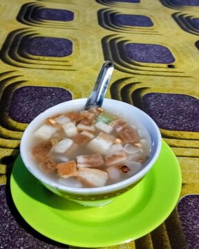 A bowl of wedang ronde a warm, traditional Javanese spiced drink&mdash;sitting on a table covered with a checkered tablecloth.