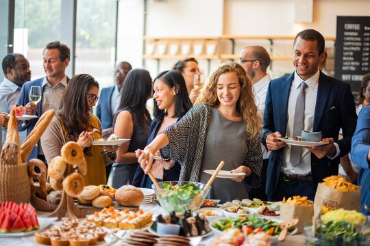 Diverse group enjoying a buffet at a social event in a bright setting.