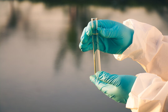 Inspector collecting river water samples to monitor pollution and ensure safe water quality.