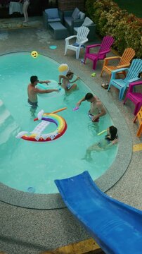 Friends are seen having fun and playing with inflatables in a backyard swimming pool. They are enjoying a refreshing and playful time during the summer.
