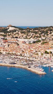 Drone footage of La Ciotat seaside town on the Mediterranean coast. Dense urban development stretching along the shoreline in southern France