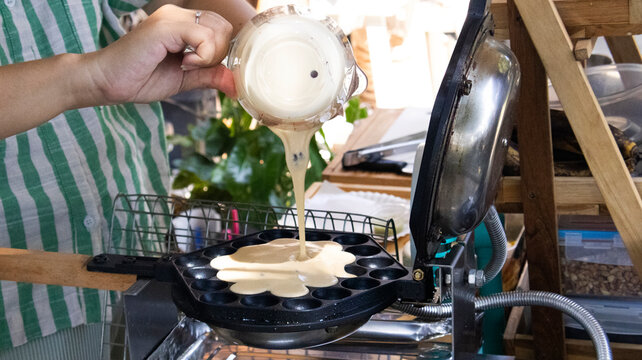 Traditional local street sweet food HongKong dessert khanom Pancake Egg waffle or bubble waffle Hong Kong served with flavors chocolate for people traveler eat at market bazaar in Nonthaburi, Thailand