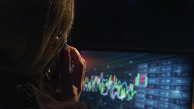 A financial analyst looks at a computer screen. A cryptocurrency specialist.