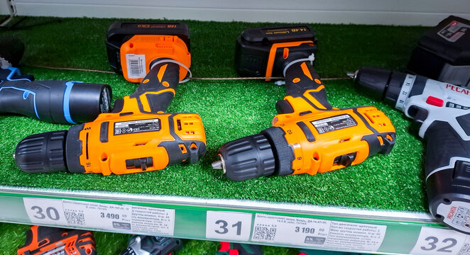 VORONEZH, Russia - April 04, 2026.Bright orange cordless drill drivers are displayed on supermarket shelves in Russia for customers to buy