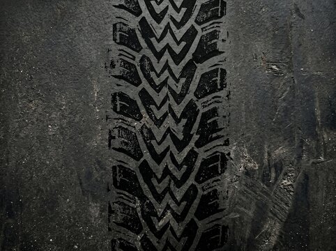 Close-up of worn tire tread on dark surface