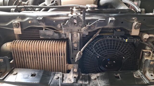 Professional auto mechanic calmly inspecting and servicing a vehicle air conditioning system in a modern, well-equipped auto repair garage.