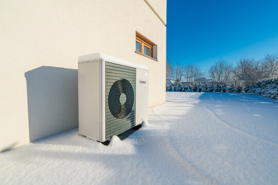 Vaillant Arotherm Plus heat pump covered in snow on sunny winter day.  Vaillant is a renowned German heating manufacturer offering advanced, energy-efficient heat pump systems