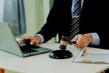 Fototapeta premium Confident legal expert confirming accuracy of litigation files on laptop next to court documents.