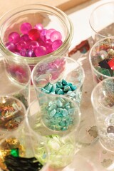 Naklejka premium Artisans engage in a dynamic jewelry making workshop, surrounded by a rainbow of gemstones and creative tools. The atmosphere buzzes with inspiration as they craft unique adornments