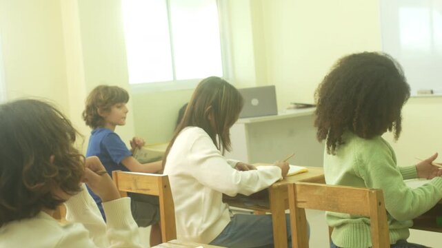 Multi-ethnic elementary school children assembling DIY robotic models during a STEM class with a senior teacher.