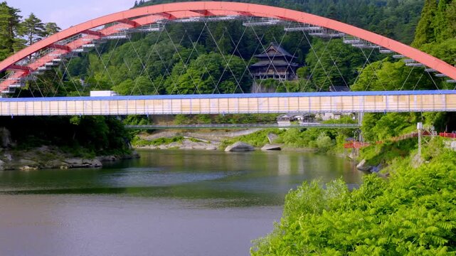 段々畑と川のある田舎の風景：右から左へ・短い・パン 
Big red bridge over the river in Japan