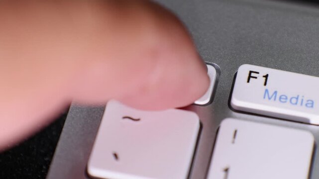 Macro video featuring the escape (Esc) key on a computer keyboard. The white key is positioned on a gray keyboard frame, with the F1 key partially visible to the right.