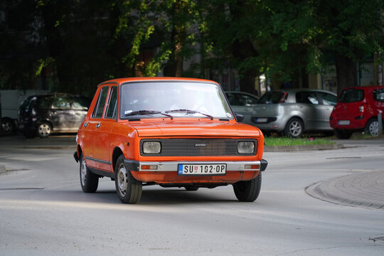Front corner view of a vintage orange  a late model 1980s Yugoslavian Zastava 101 Confort (GTL, Yugo Skala, Stojadin, licensed Fiat 128) driving in Subotica, Serbia, on June 7, 2026