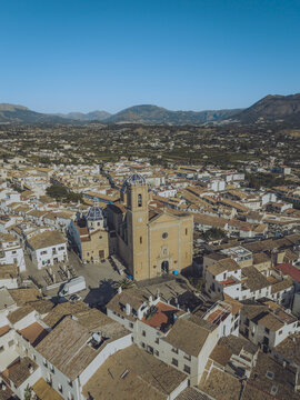 Aerial view of the Parroquia de Nuestra Senora del Consuelo with its iconic blue-tiled domes surrounded by white-washed houses and narrow streets in Altea, Valencian Community, Spain.