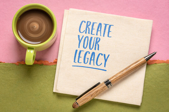 Create Your Legacy &ndash; motivational handwritten note on a napkin beside a cup of coffee, inspiring personal growth, purpose, success, ambition, and positive mindset.