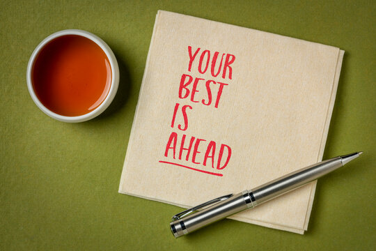 Your Best Is Ahead &ndash; inspirational handwritten note on a napkin beside a cup of tea, symbolizing hope, optimism, personal growth, success, and a positive future.