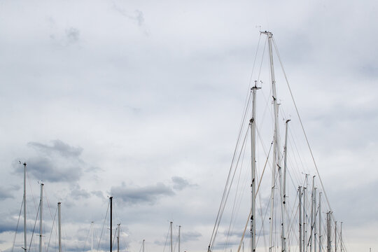 Sailboat masts against a cloudy sky