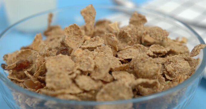 Crispy cereal flakes falling in bowl in slow motion