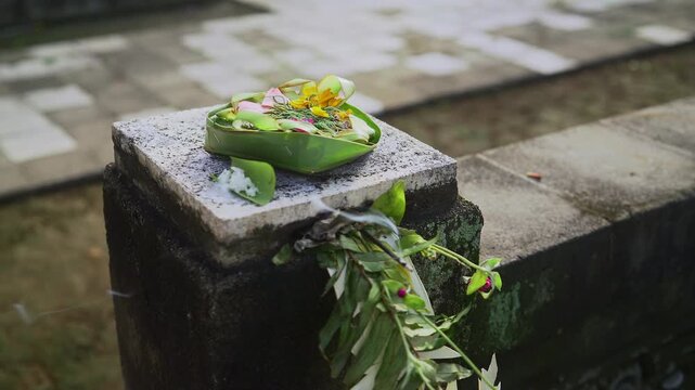 Canang Sari or Balinese Offering made from Palm Leaves and flowers with incense stick during Kuningan Ceremony in Bali. Religion, Culture, and Travel Concept