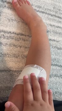 足をケガして痛がる子供の手