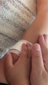 怪我をした子供の膝をなでる手