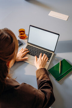 A woman using a laptop with a white screen
