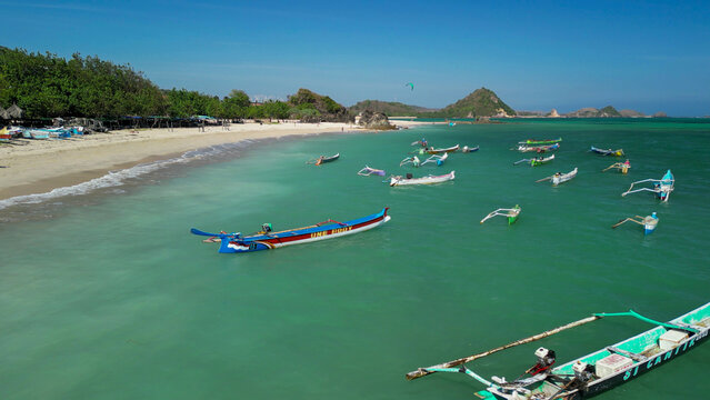 Stunning overhead panorama of Kuta Lombok coastline featuring tropical shoreline palm trees and crystal clear sea under blue sky