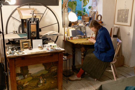 Female artist in her studio creating woodcut print