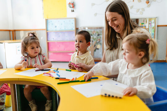 Teacher and young children learning and drawing in classroom