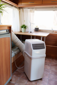 Portable air conditioner unit operating inside a modern camper van during a summer heatwave