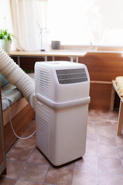Portable air conditioner unit operating inside a modern camper van during a summer heatwave