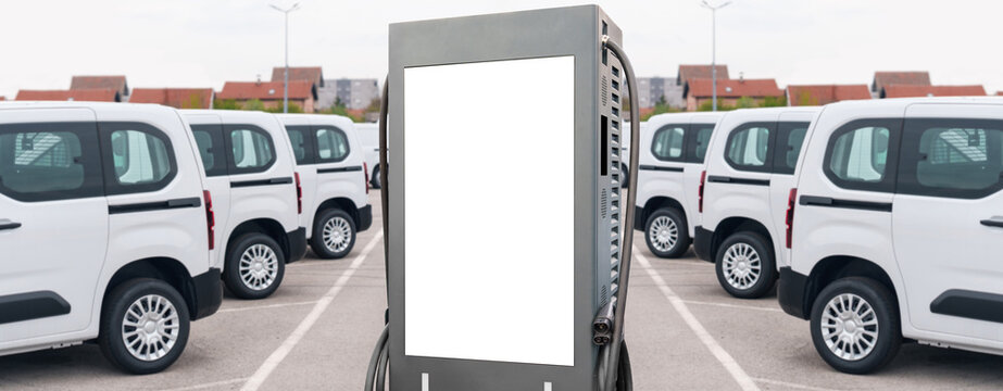 Electric vehicles charging station on a background of a row of vans. Green transportation concept