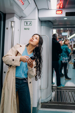 A woman standing in a subway car