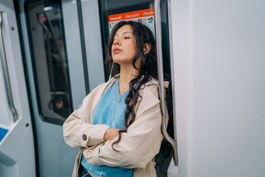 A woman standing in a subway car