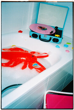 a lobster float and record player in a bathtub, 35mm film