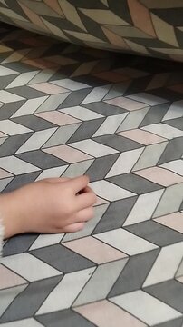 Child putting baby tooth under the pillow for Tooth Fairy, Close up of kid's hand hiding milk tooth under blanket