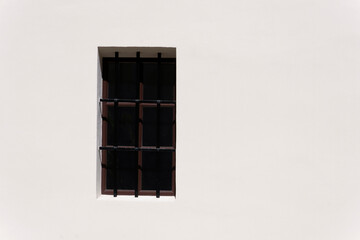 Obraz premium A classic window with decorative bars in the white wall. Krakow. Poland