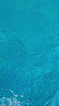Blue water ripples gently surface moving light reflecting