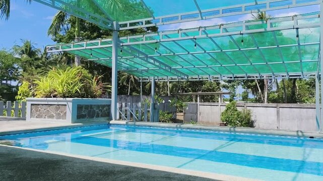 Blue pool under green canopy with tropical plants surrounding