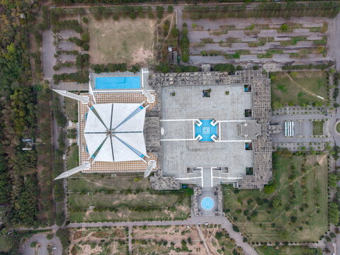 Aerial view of Faisal Masjid, featuring its iconic tent-shaped roof, four minarets, stone courtyard, and surrounding gardens, Islamabad, Islamabad Capital Territory, Pakistan.