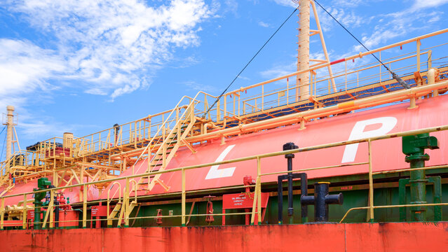 Large LPG storage tank on tanker ship under blue sky. Liquefied petroleum gas transportation and maritime energy logistics industry, perspective side view