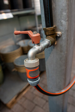 Orange handle grips metal pipe attached to gray pole