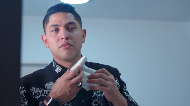 Mexican musician tying a bow tie in the mirror