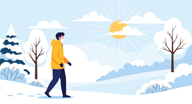 Man wearing a warm yellow jacket and a protective face mask walking through a snowy winter landscape on a bright sunny morning.