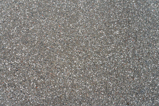 Close-up of dark asphalt road surface with aggregate texture