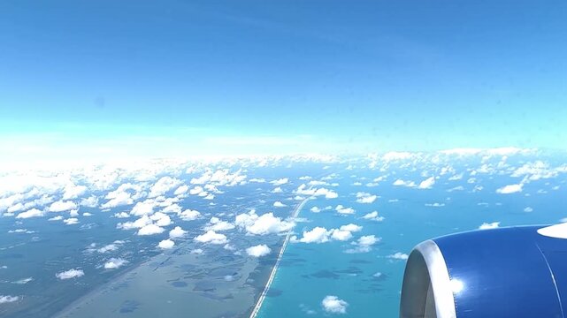 Aerial Boundary: 4K Window View of an Airplane Crossing Over the Sandy Coastline, Barrier Islands, and Deep Blue Ocean of Central Florida